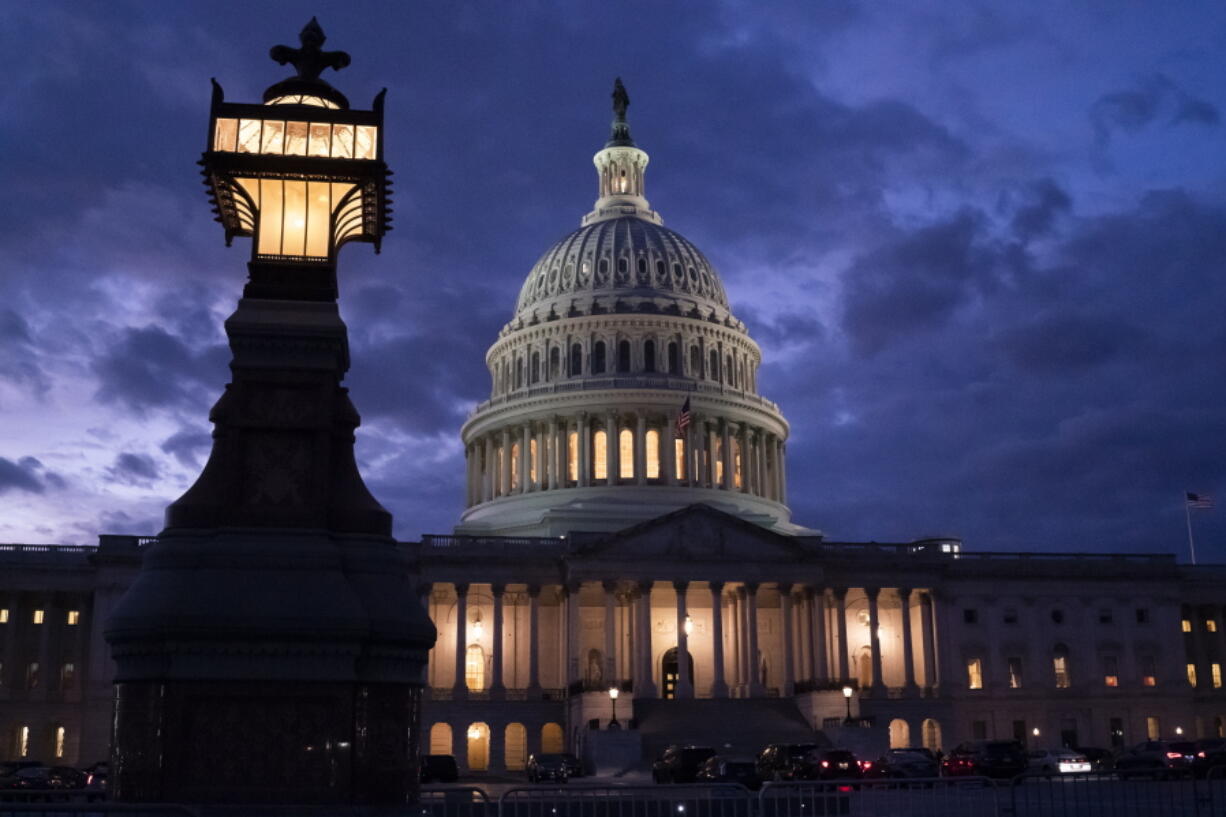 Night falls at the the Capitol in Washington, Thursday, Dec. 2, 2021, with the deadline to fund the government approaching. Republicans in the Senate are poised to stall a must-pass funding bill as they force a debate on rolling back the Biden administration's COVID-19 vaccine mandates for some workers. (AP Photo/J.