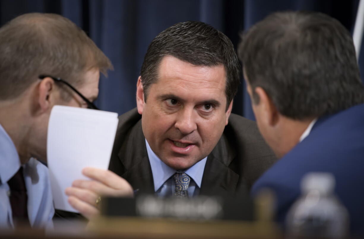 FILE - Rep. Devin Nunes, R-Calif, the then ranking member of the House Intelligence Committee, center, talks with Rep. Jim Jordan, R-Ohio, left and Rep. John Ratcliffe, R-Texas, during a break in a the House Judiciary Committee hearing considering the investigative findings in the impeachment inquiry against President Donald Trump, on Capitol Hill in Washington, Dec. 9, 2019. Nunes is leaving the House at the end of this year to lead former President Donald Trump's effort to launch a social media platform intended to rival Twitter. A statement from the Trump Media & Technology group said Nunes would serve as chief executive officer, beginning in January 2022. (AP Photo/J.