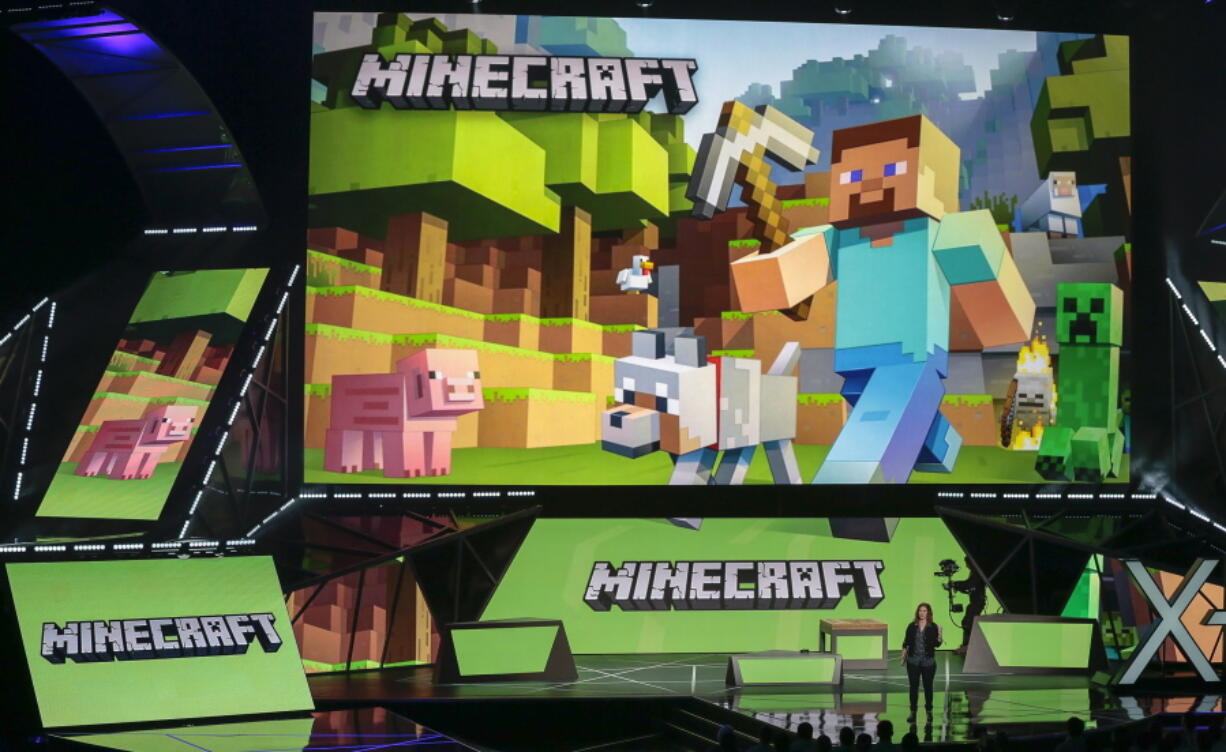 FILE - Lydia Winters shows off Microsoft's "Minecraft" built specifically for HoloLens at the Xbox E3 2015 briefing before Electronic Entertainment Expo, June 15, 2015, in Los Angeles. Security experts around the world raced Friday, Dec. 10, 2021, to patch one of the worst computer vulnerabilities discovered in years, a critical flaw in open-source code widely used across industry and government in cloud services and enterprise software. Cybersecurity experts say users of the online game Minecraft have already exploited it to breach other users by pasting a short message into in a chat box.