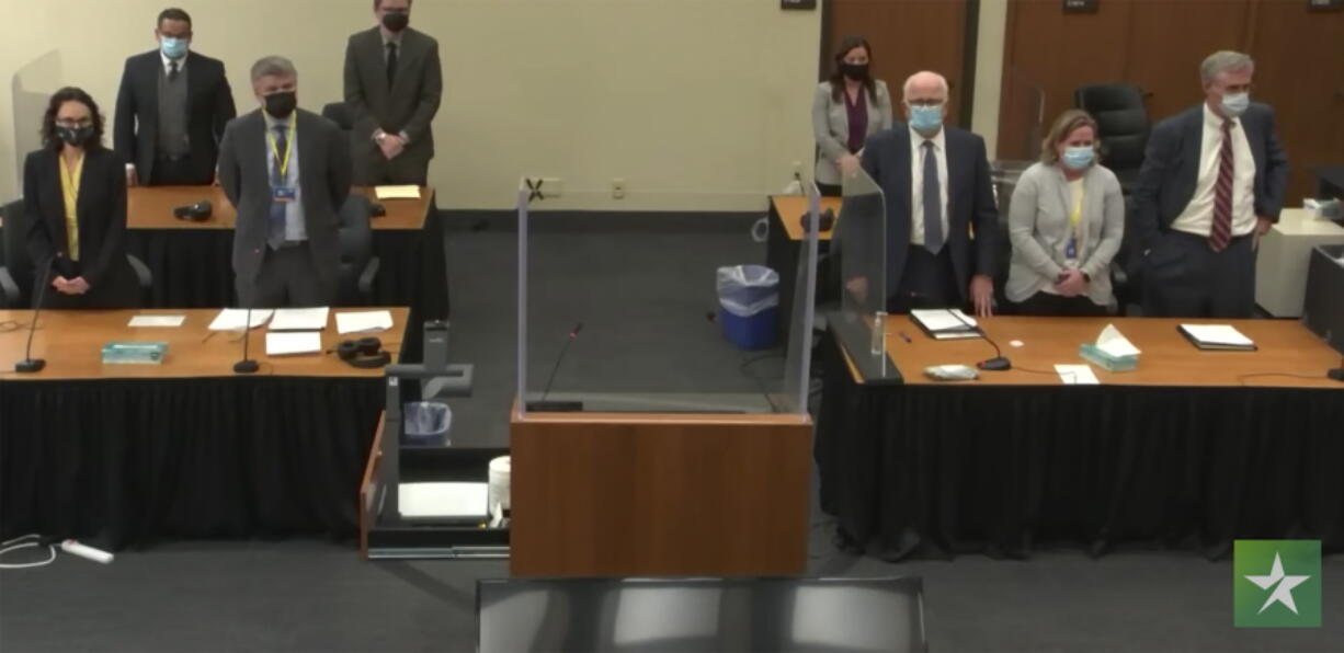 In this image taken from video, the prosecution, left, and the defense, right, stand, as the jury enters the courtroom to deliver a question to Hennepin County Judge Regina Chu, during deliberations Tuesday, Dec. 21, 2021, in former Brooklyn Center police Officer Kim Potter's trial for the April 11 death of Daunte Wright, at the Hennepin County Courthouse in Minneapolis.