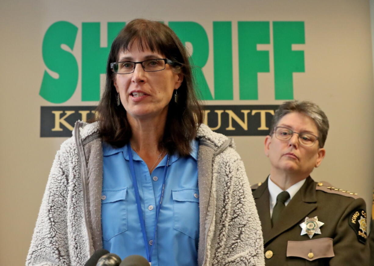 In this 2019 photo, King County Detective Kathleen Decker speaks at a news conference, while Sheriff Mitzi G. Johanknecht looks on, at right, in Seattle. Decker, a now-retired 33-year veteran of the King County Sheriff's Office, made several false statements under oath when she obtained a search warrant in a murder case in 2019, resulting in a man's false arrest on drug charges, newly unsealed federal court orders show.