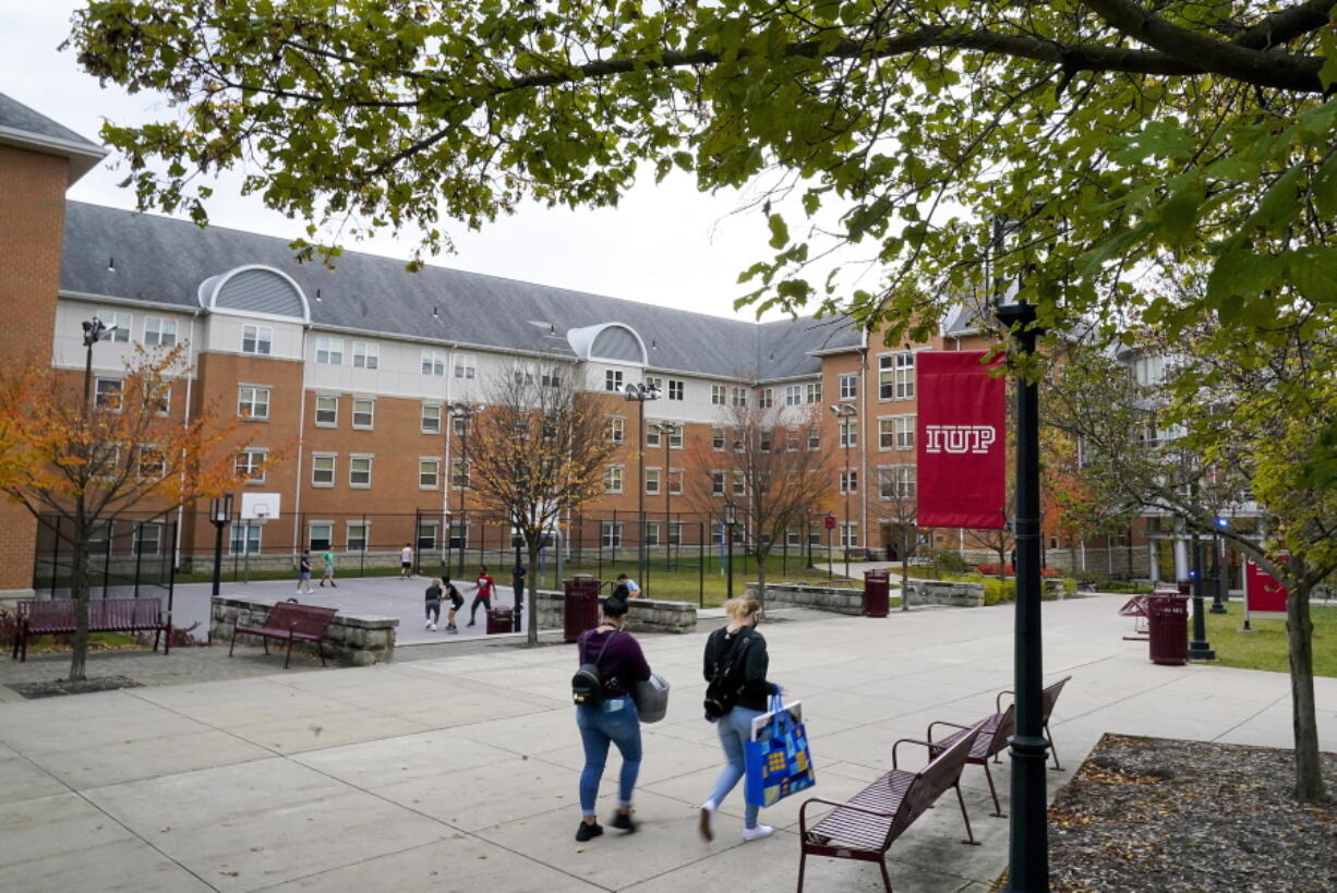 FILE - Students walk on the campus of Indiana University of Pennsylvania in Indiana, Pa., Oct. 21, 2020. The Biden administration on Wednesday, Dec. 22, 2021, extended a student loan moratorium that has allowed millions of Americans to put off debt payments during the pandemic. Under the action, payments on federal student loans will remain paused through May 1, 2022. (AP Photo/Gene J.