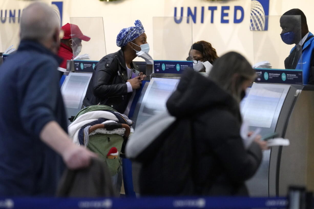 Travelers check in at the airline ticket counters at O'Hare International Airport in Chicago, Thursday, Dec. 30, 2021. (AP Photo/Nam Y.