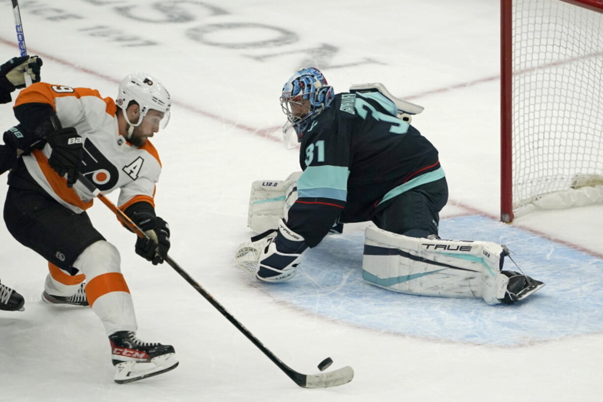 Philadelphia Flyers defenseman Ivan Provorov, left, scores in overtime gainst Seattle Kraken goaltender Philipp Grubauer during an NHL hockey game Wednesday, Dec. 29, 2021, in Seattle. The Flyers won 3-2. (AP Photo/Ted S.