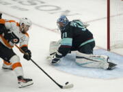 Philadelphia Flyers defenseman Ivan Provorov, left, scores in overtime gainst Seattle Kraken goaltender Philipp Grubauer during an NHL hockey game Wednesday, Dec. 29, 2021, in Seattle. The Flyers won 3-2. (AP Photo/Ted S.