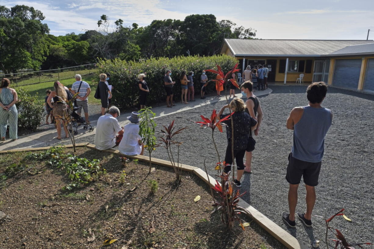 People queue outside a school to vote in a referendum in Noumea, New Caledonia, Sunday Dec.12, 2021. Voters in the South Pacific archipelago of New Caledonia decide whether to break away from France, a referendum that is important for French geopolitical ambitions and is being closely watched amid growing Chinese influence in the region. But pro-independence forces are refusing to take part, accusing the French government of trying to rush through the vote.