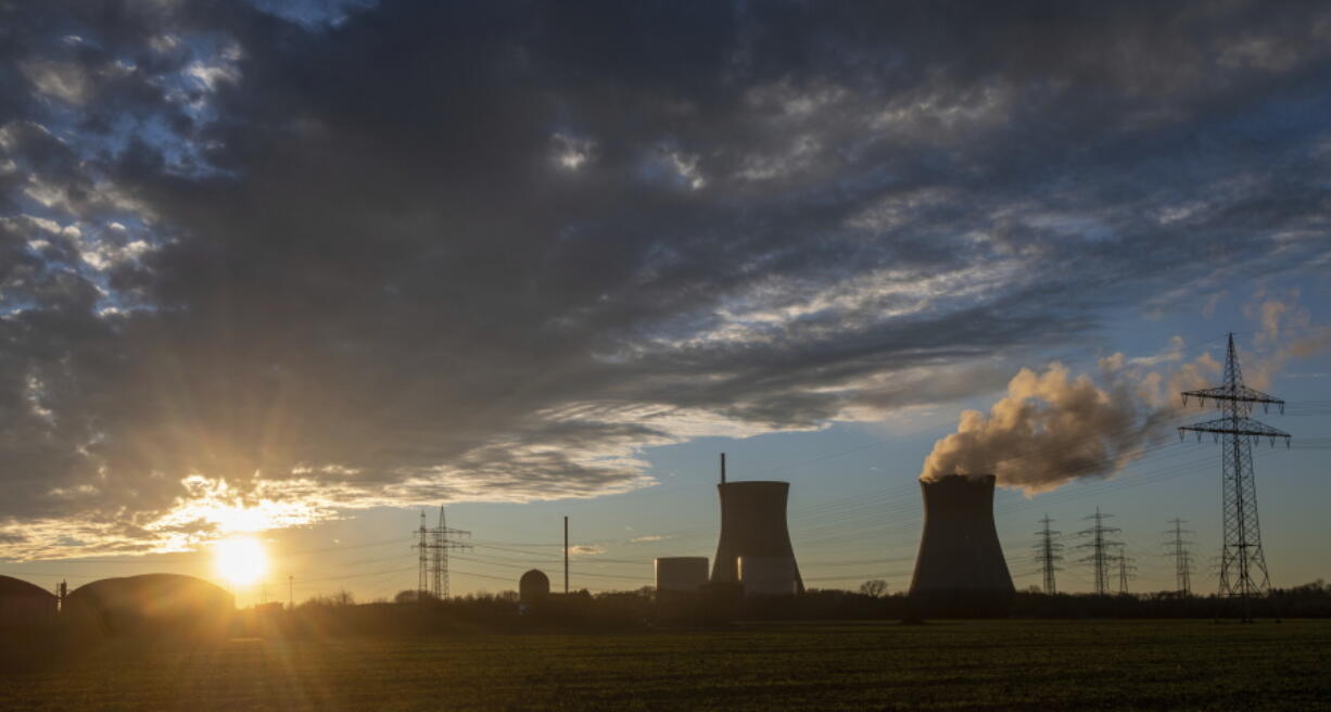 Steam rises from the cooling tower of the nuclear power plant of Gundremmingen, Bavaria, Friday, Dec. 31, 2021. Bavaria's penultimate nuclear reactor will go offline today.