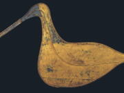 This image provided by the American Folk Art Museum shows the Hudsonian Curlew weather vane. The museum's curator, Emelie Gevalt, said one of her favorite pieces in the exhibit is the museum's own "Hudsonian Curlew." The 1874 piece is large, nearly 7 feet tall and 4 feet wide. A relatively simple design, it depicts the body and distinctive curved beak of the shorebird in gold-leafed sheet metal, and once sat atop the Curlew Bay sportsmen's club in Seaville, New Jersey.