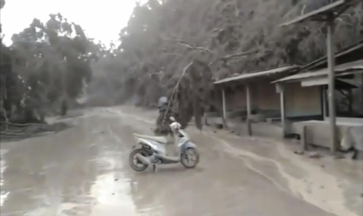 Ash covers the street in the Lumajang District in Indonesia, on Saturday, Dec. 4, 2021 after Mount Semeru's eruption.   Indonesia's highest volcano on Java island has spewed thick columns of ash, searing gas and lava down its slopes in a sudden eruption triggered by heavy rains.