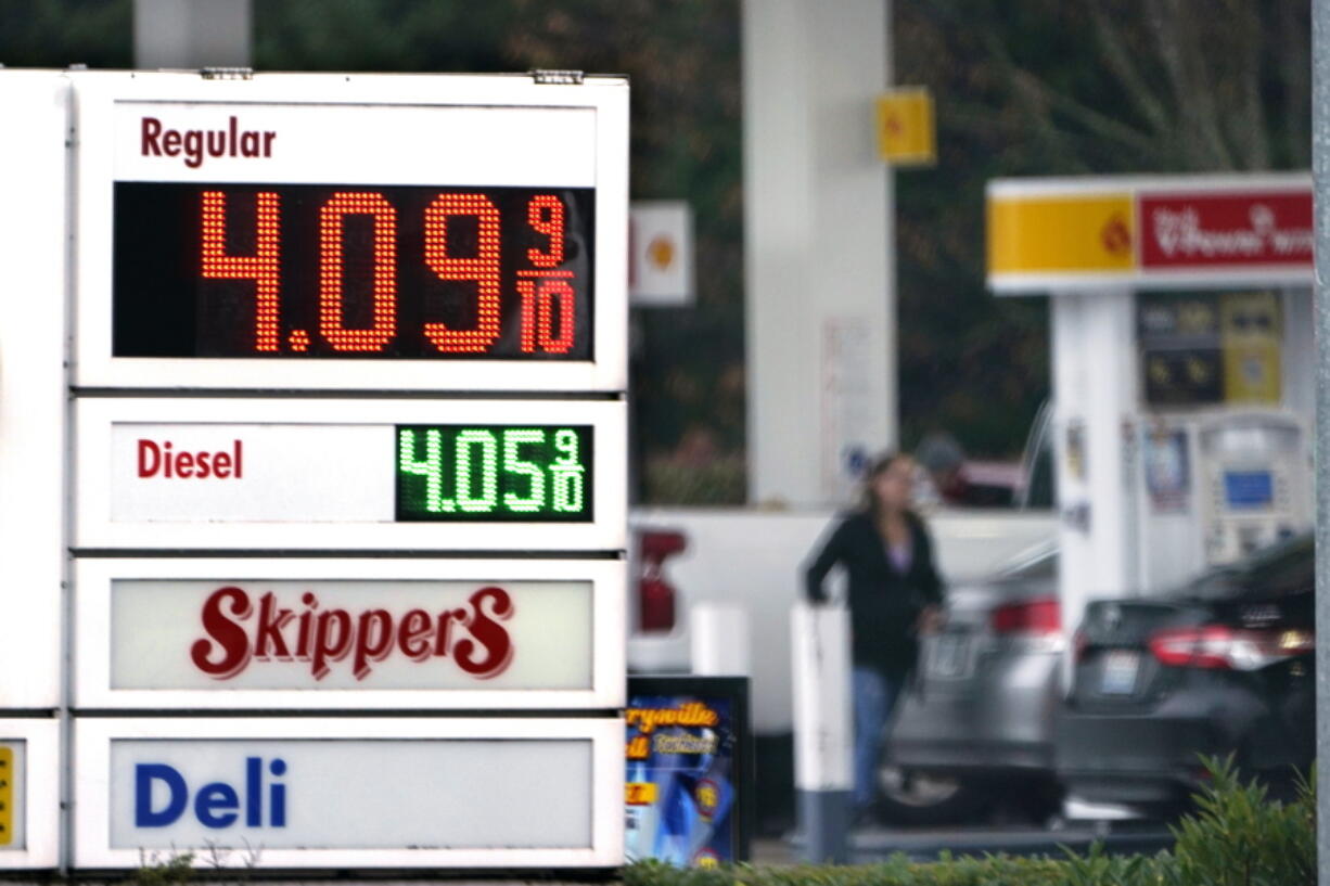 FILE - A driver fills a tank at a gas station Friday, Dec. 10, 2021, in Marysville, Wash.  Consumer prices rose 6.8% for the 12 months ending in November, a 39-year high. Many economists expect inflation to remain near this level a few more months but to then moderate through 2022 for a variety of reasons. And they don't see a repeat of the 1970s or early 1980s, when inflation ran above 10% for frighteningly long stretches.