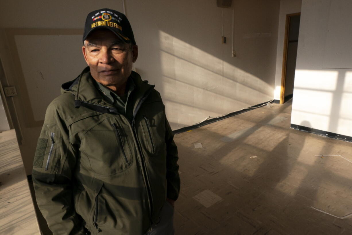 Dan Martinez, emergency manager for the Confederated Tribes of Warm Springs, poses for a photo in a storage building filled with donated water on Tuesday, Dec. 7, 2021, in Warm Springs, Ore. "The infrastructure bill brought joy to my heart because now it gives me hope -- hope that it's going to be repaired," said Martinez, the tribes' emergency manager, who expects to receive federal funds to replace underground pipes and address the 40-year-old treatment plant.