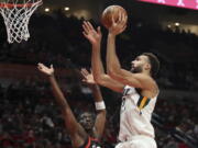 Utah Jazz center Rudy Robert shoots over Portland Trail Blazers forward Tony Snell during the first half of an NBA basketball game in Portland, Ore., Wednesday, Dec. 29, 2021.