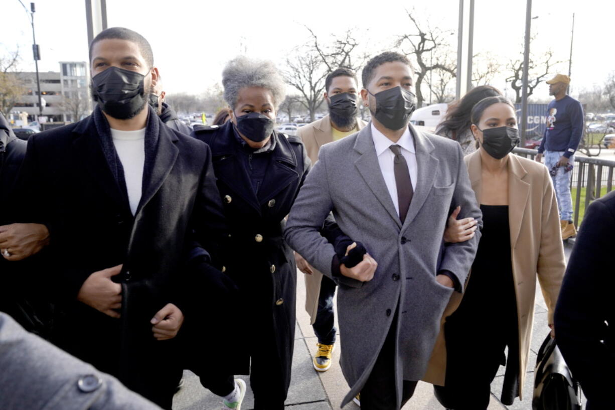 FILE - Actor Jussie Smollett, center, arrives with family Thursday, Dec. 2, 2021, at the Leighton Criminal Courthouse on day four of his trial in Chicago. Smollett is accused of lying to police when he reported he was the victim of a racist, anti-gay attack in downtown Chicago nearly three years ago.