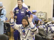 In this photo released by the Roscosmos Space Agency, spaceflight participant Yusaku Maezawa of Japan, member of the main crew of the new Soyuz mission to the International Space Station (ISS) gestures prior the launch at the Russian leased Baikonur cosmodrome, Kazakhstan, Wednesday, Dec. 8, 2021.