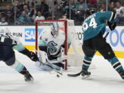 Seattle Kraken goaltender Chris Driedger (60) blocks a goal attempt against San Jose Sharks left wing Alexander Barabanov (94) as Jeremy Lauzon (55) defends during the first period of an NHL hockey game Tuesday, Dec. 14, 2021, in San Jose, Calif.