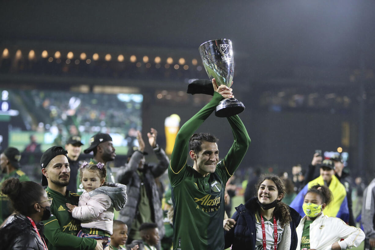 Portland Timbers midfielder Diego Valeri (8) holds up the Western Conference trophy following the team's 2-0 victory over Real Salt Lake in the MLS soccer Western Conference final Saturday, Dec. 4, 2021, in Portland, Ore.