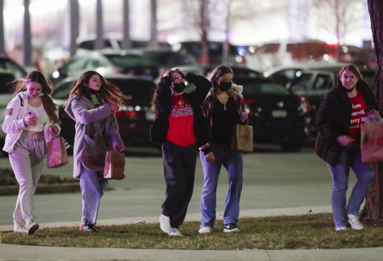 People leave Oak Brook Center Mall after a reported shooting in Oak Brook, Ill. on Thursday, Dec. 23, 2021. Police say a shooting occurred at the mall full of Christmas shoppers in suburban Chicago, injuring four people. The incident began with two people involved in a shootout in a corridor.