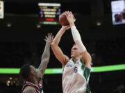 Dallas Mavericks center Kristaps Porzingis shoots over Portland Trail Blazers forward Nassir Little during the second half of an NBA basketball game in Portland, Ore., Monday, Dec. 27, 2021.