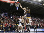 Gonzaga center Chet Holmgren, center left, dunks next to Merrimack guard Malik Edmead during the first half of an NCAA college basketball game, Thursday, Dec. 9, 2021, in Spokane, Wash.