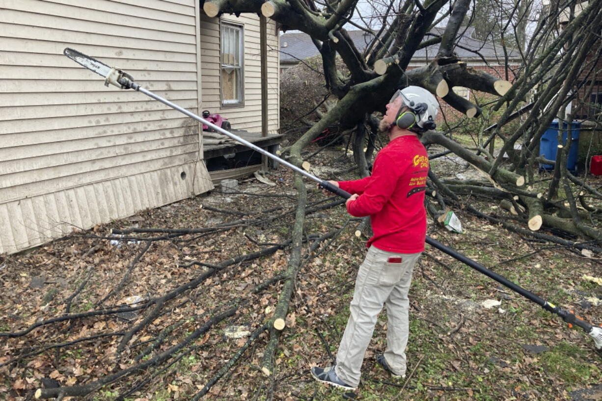 Chris Chiles, disaster response coordinator for Virginia-based God's Pit Crew, works a chainsaw on a fallen tree outside a home in the aftermath of a tornado in Mayfield, Ky., Thursday, Dec. 16, 2021. The damage and devastation in Mayfield is so severe that it could take years before the community returns to normal, said  Chiles. Virginia-based God's Pit Crew, of Danville, has been aiding storm-ravaged communities for more than two decades.