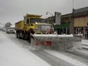 A snow plow travels down a street in Tenino, Wash. on Sunday, Dec. 26, 2021. Several inches of snow fell overnight in the south sound area which made traveling a challenge on many parts of Thurston County.