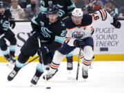 Edmonton Oilers center Connor McDavid (97) pursues Seattle Kraken center Alex Wennberg (21) during the first period of an NHL hockey game Friday, Dec. 3, 2021, in Seattle.