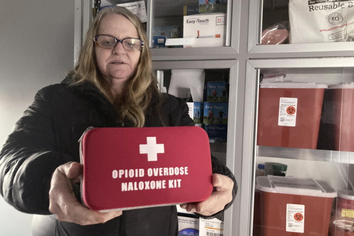 FILE - Debra Cross, director of operations for Provoking Hope, an addiction recovery center in McMinnville, Ore., displays an emergency kit used to treat opioid overdose as she stands inside an ambulance converted into a mobile needle-exchange unit on Dec. 9, 2021. Oregon Attorney General Ellen Rosenblum has announced an agreement with Oregon's cities and counties for the allocation of Oregon's approximately $329 million share of an historic $26 billion national settlement with the three largest distributors of opioids and the drug manufacturer.