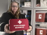 FILE - Debra Cross, director of operations for Provoking Hope, an addiction recovery center in McMinnville, Ore., displays an emergency kit used to treat opioid overdose as she stands inside an ambulance converted into a mobile needle-exchange unit on Dec. 9, 2021. Oregon Attorney General Ellen Rosenblum has announced an agreement with Oregon's cities and counties for the allocation of Oregon's approximately $329 million share of an historic $26 billion national settlement with the three largest distributors of opioids and the drug manufacturer.