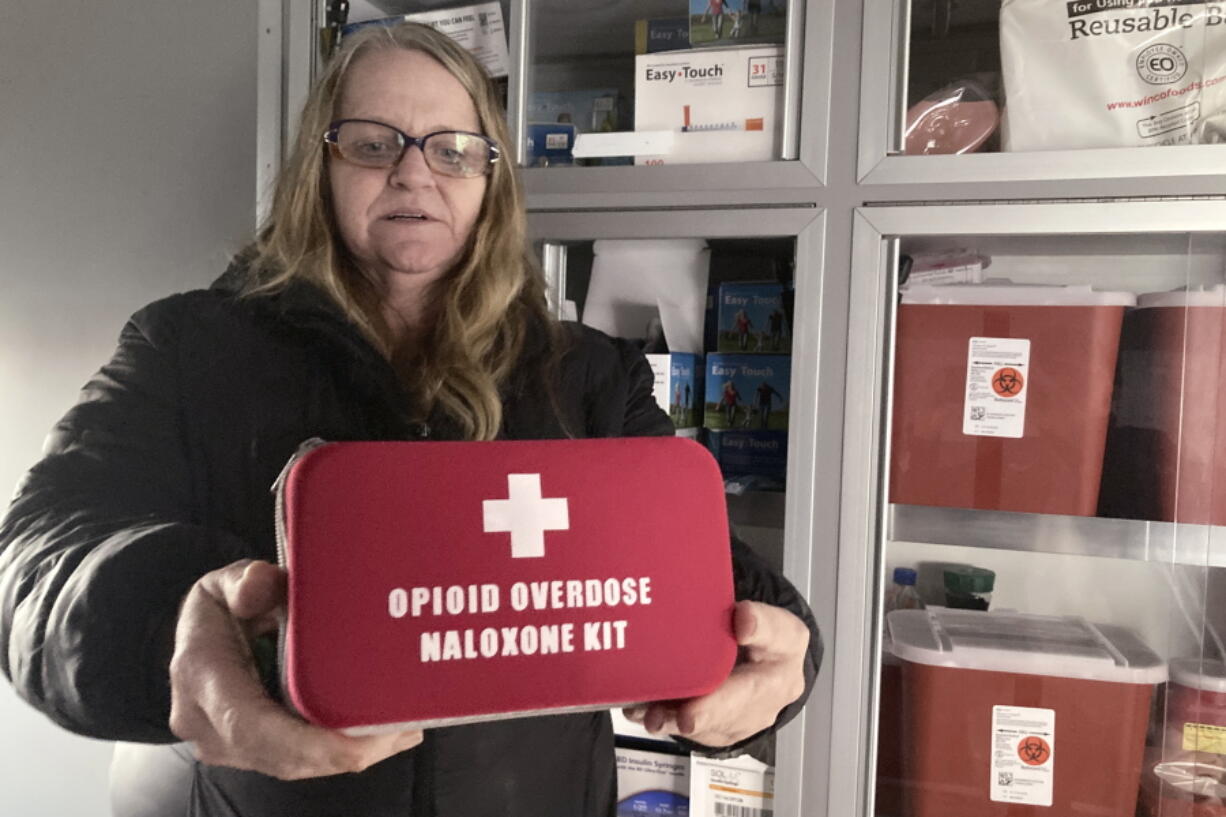 Debra Cross, director of operations for Provoking Hope, an addiction recovery center in McMinnville, Ore., displays an emergency kit used to treat opioid overdose as she stands inside an ambulance converted into a mobile needle-exchange unit. McMinnville and thousands of other towns across the United States that were wracked by the opioid crisis are on the precipice of receiving billions of dollars in the second-biggest legal settlement in U.S. history.