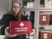 Debra Cross, director of operations for Provoking Hope, an addiction recovery center in McMinnville, Ore., displays an emergency kit used to treat opioid overdose as she stands inside an ambulance converted into a mobile needle-exchange unit. McMinnville and thousands of other towns across the United States that were wracked by the opioid crisis are on the precipice of receiving billions of dollars in the second-biggest legal settlement in U.S. history.