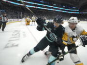 Seattle Kraken center Mason Appleton, left, and Pittsburgh Penguins defenseman Chad Ruhwedel, right, go up against the boards during the first period of an NHL hockey game, Monday, Dec. 6, 2021, in Seattle. (AP Photo/Ted S.