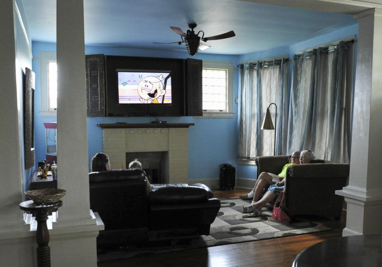 Family members gather in the living room of a local Airbnb property on Aug. 26, 2017, in Brownsville, Texas. Thousands of Airbnb hosts have agreed to house refugees as part of the online lodging marketplace's philanthropic program to provide emergency temporary housing to those who need it. It's a program so successful it is seen as a model for those working to resettle refugees and has become a core mission of Airbnb.org, the nonprofit that celebrates its first anniversary Tuesday, Dec. 7, 2021. Airbnb's philanthropy started in 2012 after Hurricane Sandy and continued for years, including Hurricane Harvey in 2017 before it expanded its scope.