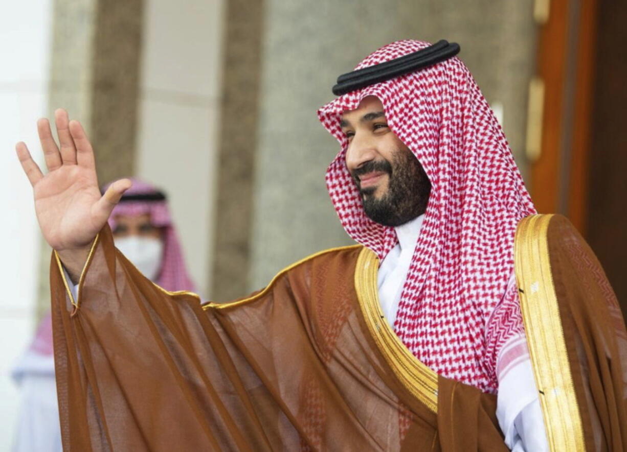 FILE - In this photo released by Saudi Royal Palace, Saudi Crown Prince Mohammed bin Salman, waves to French President Emmanuel Macron, upon his arrival in Jiddah, Saudi Arabia, Dec. 4, 2021. Saudi Arabia's crown prince was heading Monday, Dec. 6, 2021, to Oman, the first stop of a tour of Gulf Arab states that will see him meet neighboring rulers and allies as the kingdom closely watches negotiations in Europe to revive Iran's nuclear deal with world powers.