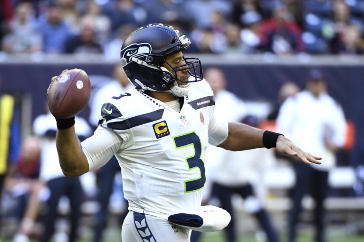 Seattle Seahawks quarterback Russell Wilson (3) throws against the Houston Texans during the first half of an NFL football game, Sunday, Dec. 12, 2021, in Houston.