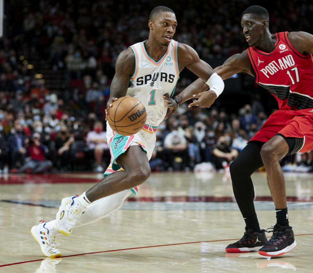 San Antonio Spurs guard Lonnie Walker IV, left, dribbles past Portland Trail Blazers forward Tony Snell during the first half of an NBA basketball game in Portland, Ore., Thursday, Dec. 2, 2021.