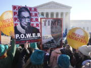 People demonstrate in front of the U.S. Supreme Court Wednesday, Dec. 1, 2021, in Washington, as the court hears arguments in a case from Mississippi, where a 2018 law would ban abortions after 15 weeks of pregnancy, well before viability.