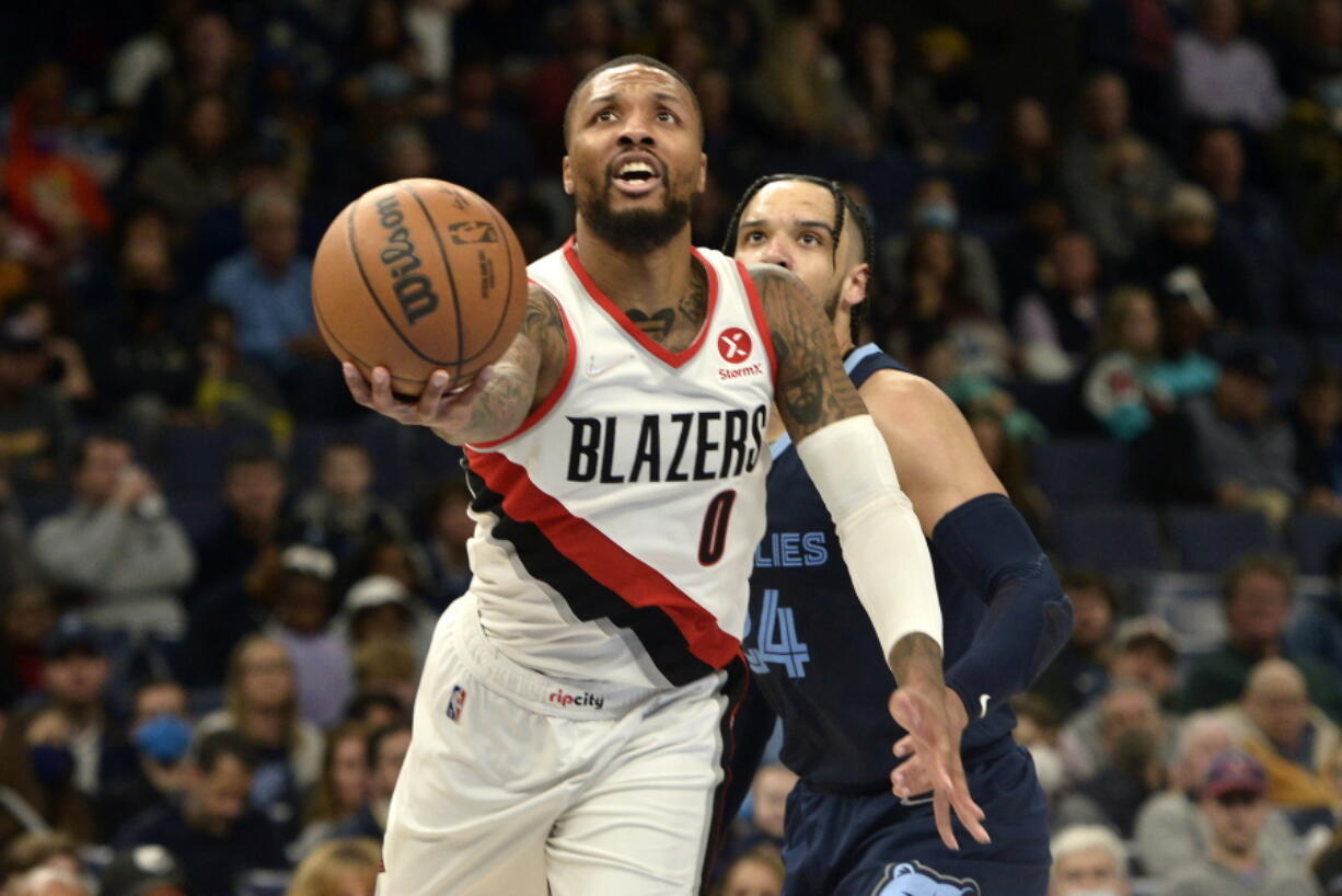 Portland Trail Blazers guard Damian Lillard (0) shoots ahead of Memphis Grizzlies forward Dillon Brooks (24) in the first half of an NBA basketball game Sunday, Dec. 19, 2021, in Memphis, Tenn.