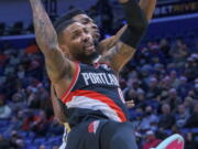 Portland Trail Blazers guard Damian Lillard (0) loses the ball as he collides withNew Orleans Pelicans forward Herbert Jones during the first half of an NBA basketball game in New Orleans, Tuesday, Dec. 21, 2021.