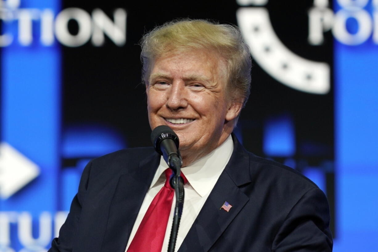 FILE - In this July 24, 2021, file photo former President Donald Trump smiles as he pauses while speaking to supporters at a Turning Point Action gathering in Phoenix. Trump's new social media company forecasts it may have 81 million users by 2026, or nearly 7 million more people than voted for him in the last U.S. presidential election. The projection was filed on Monday, Dec. 6, 2021 with securities regulators by the company trying to bring Trump Media & Technology Group to the stock market. (AP Photo/Ross D.