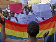 FILE - Women in Cape Town, South Africa, protest a sentence given to two men under Malawi's anti-gay legislation on May 20, 2010. Desmond Tutu is being remembered for his passionate advocacy on behalf of LGBTQ people as well as his fight for racial justice. But the South African archbishop's campaign against homophobia had limited impact in the rest of Africa.