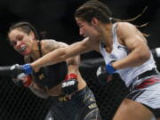 Julianna Pena, right, throws a right to Amanda Nunes during a women's bantamweight mixed martial arts title bout at UFC 269, Saturday, Dec. 11, 2021, in Las Vegas.