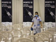 FILE - A worker disinfects chairs at a new vaccination center in Lisbon, Tuesday, Nov. 30, 2021. A pandemic-weary world faces weeks of confusing uncertainty as countries restrict travel and take other steps to halt the newest potentially risky coronavirus mutant before anyone knows just how dangerous omicron really is.