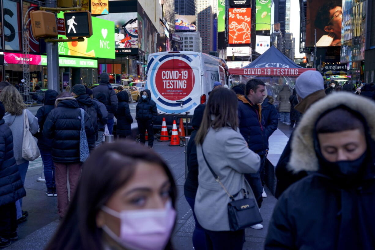 FILE - People wait in a long line to get tested for COVID-19 in Times Square, New York, Dec. 20, 2021. U.S. health officials' decision to shorten the recommended COVID-19 isolation and quarantine period from 10 days to five is drawing criticism from some medical experts and could create confusion among many Americans.