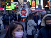 FILE - People wait in a long line to get tested for COVID-19 in Times Square, New York, Dec. 20, 2021. U.S. health officials' decision to shorten the recommended COVID-19 isolation and quarantine period from 10 days to five is drawing criticism from some medical experts and could create confusion among many Americans.