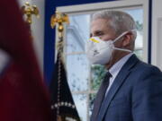 Dr. Anthony Fauci, the top U.S. infectious disease expert, wears a face mask as he arrives for the the White House COVID-19 Response Team's regular call with the National Governors Association in the South Court Auditorium in the Eisenhower Executive Office Building on the White House Campus, Monday, Dec. 27, 2021, in Washington. Fauci says the U.S. should consider a vaccination mandate for domestic air travel as coronavirus infections surge. To date the Biden administration has balked at the idea, anticipating legal entanglements.