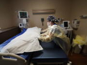 FILE - Medical staff move a COVID-19 patient who died onto a gurney to hand off to a funeral home van, at the Willis-Knighton Medical Center in Shreveport, La., Aug. 18, 2021. The U.S. death toll from COVID-19 topped 800,000, a once-unimaginable figure seen as doubly tragic, given that more than 200,000 of those lives were lost after the vaccine became available practically for the asking.