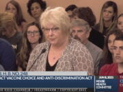 In this June 8, 2021, photo provided by the The Ohio Channel, Dr. Sherri Tenpenny speaks at a Ohio House Health Committee in Columbus, Ohio. The Cleveland-based osteopathic doctor testified that COVID-19 vaccines cause magnetism. "They can put a key on their forehead; it sticks," said Tenpenny.