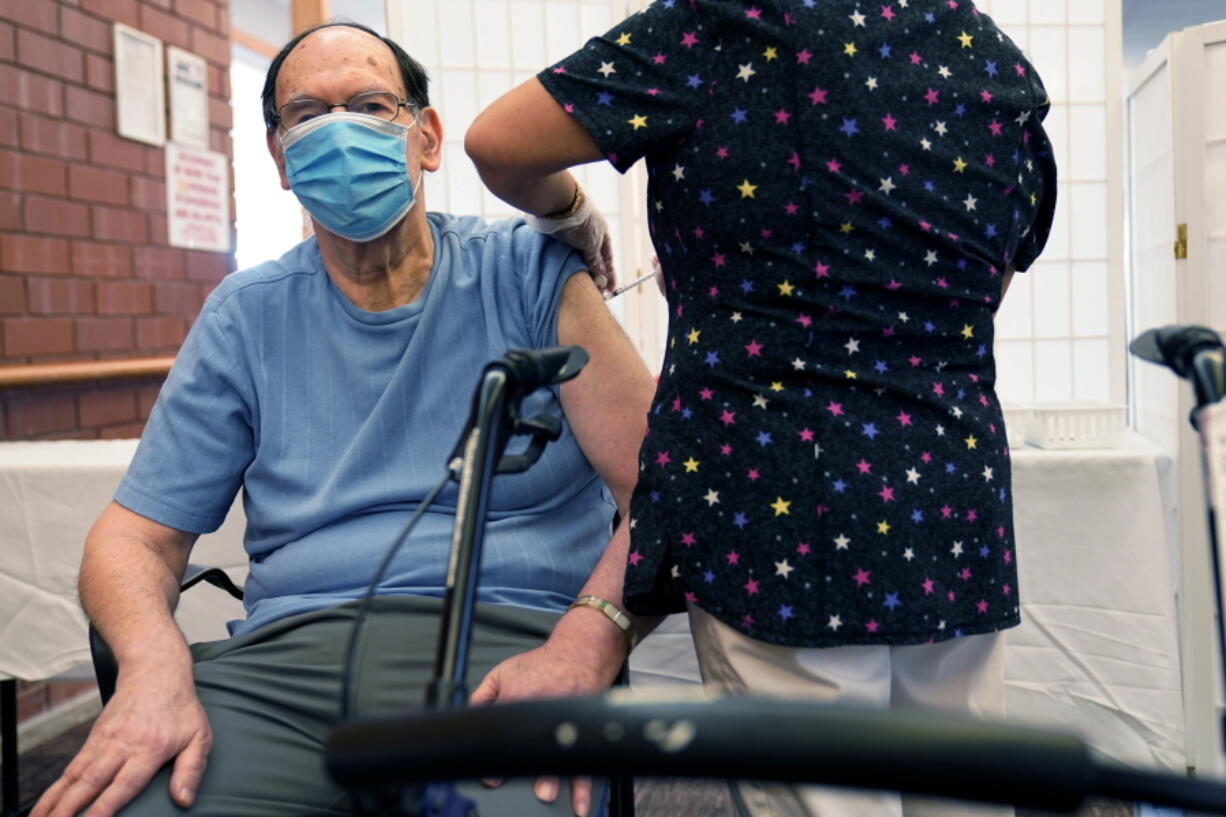 FILE - Marvin Marcus, 79, a resident at the Hebrew Home at Riverdale, receives a COVID-19 booster shot in New York, Sept. 27, 2021.  Federal health officials call on nursing homes to redouble efforts to administer COVID-19 booster shots to residents and staff amid sharply rising cases among staff and lagging rates of booster vaccination.