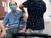 FILE - Marvin Marcus, 79, a resident at the Hebrew Home at Riverdale, receives a COVID-19 booster shot in New York, Sept. 27, 2021.  Federal health officials call on nursing homes to redouble efforts to administer COVID-19 booster shots to residents and staff amid sharply rising cases among staff and lagging rates of booster vaccination.