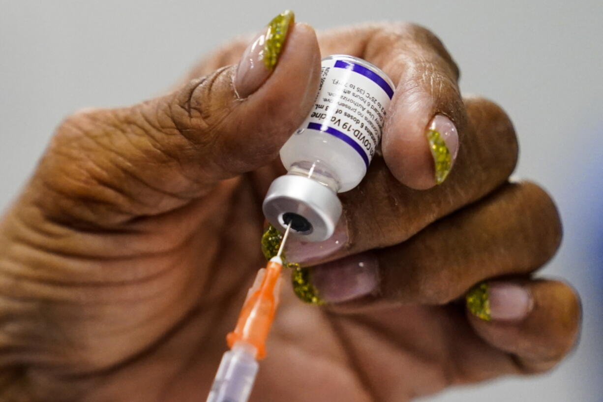 A syringe is prepared with the Pfizer COVID-19 vaccine at a vaccination clinic at the Keystone First Wellness Center in Chester, Pa., Wednesday, Dec. 15, 2021.